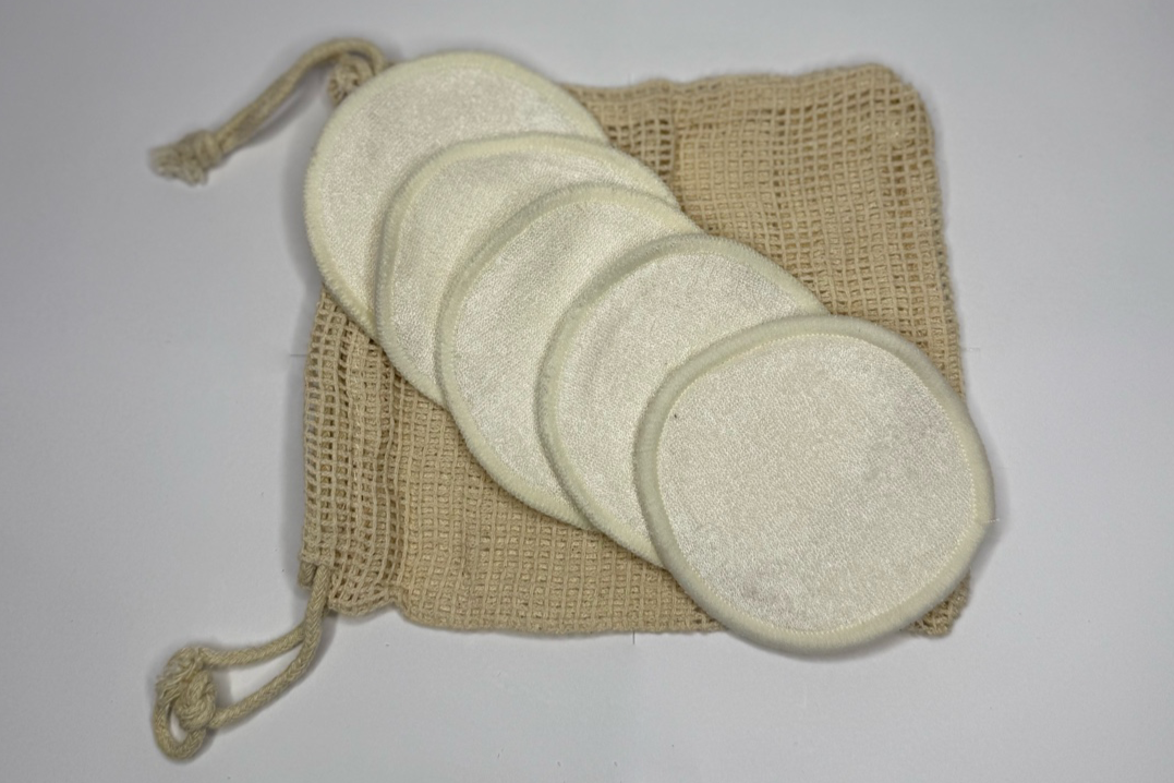 Set of round cotton pads with a drawstring bag on a gray background