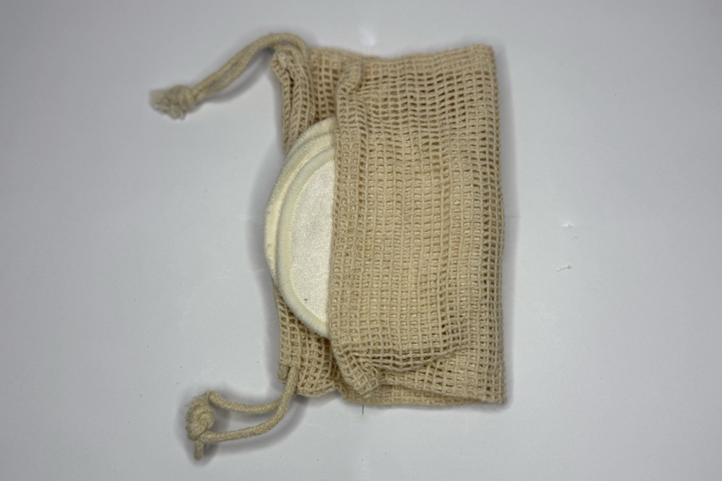 Jute bag with a white disc inside on a gray background